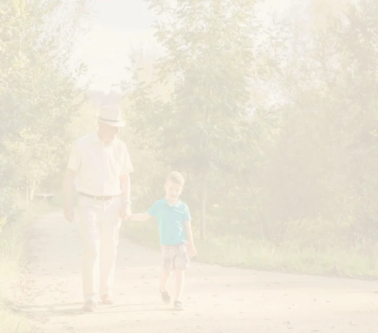 A man and boy walking on the sidewalk.