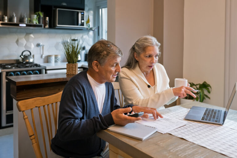 a man and woman looking at a laptop